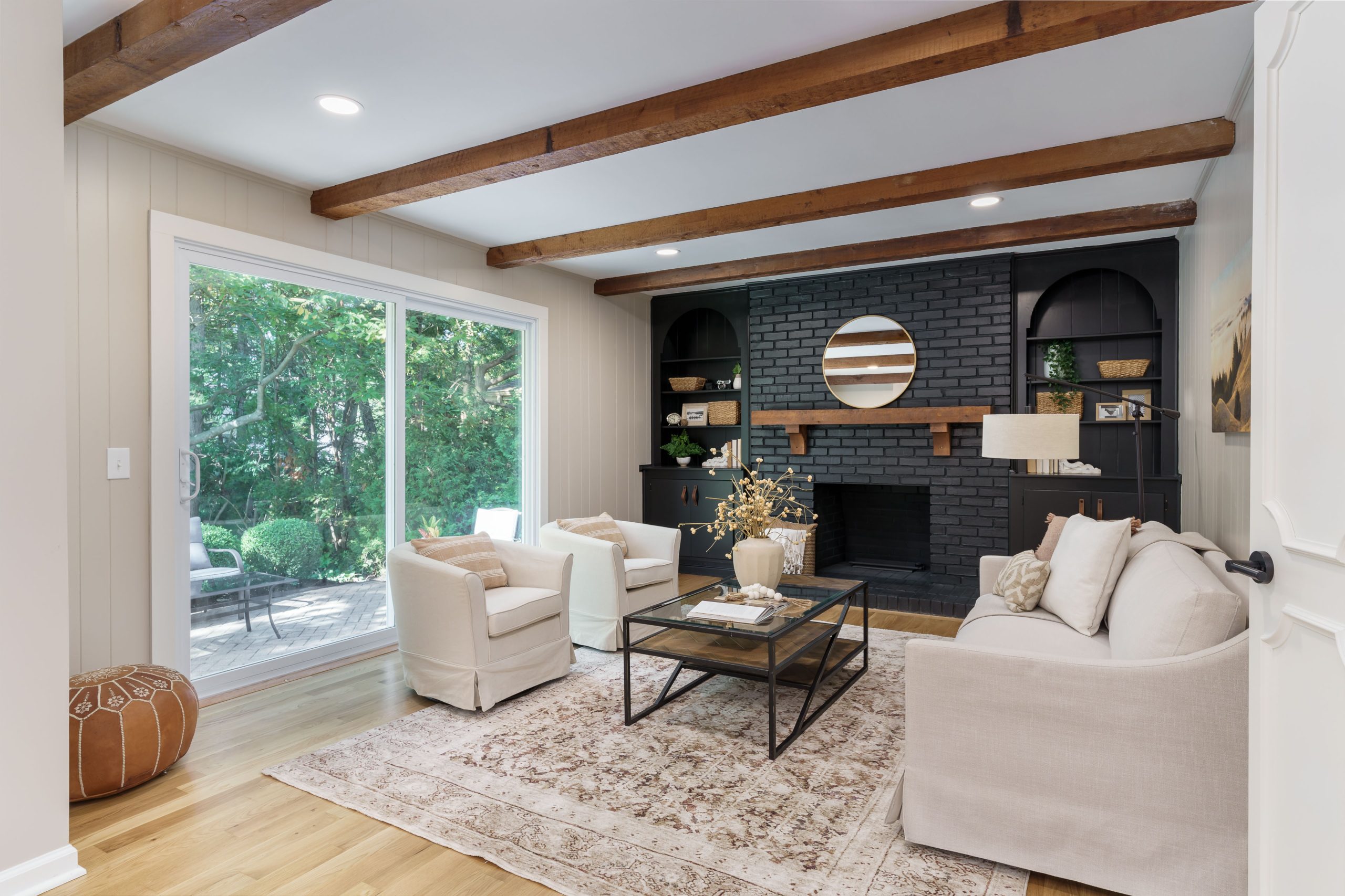 Living room design in a central Ohio staging completed with swivel round back chairs, large sofa and industrial coffee table.