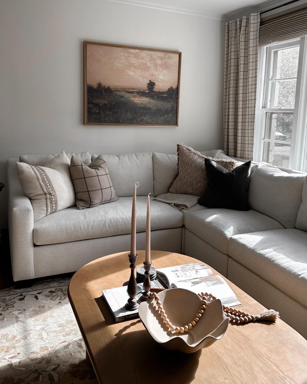 Living room interior design project with large sectional sofa rounded coffee table and framed wall art.