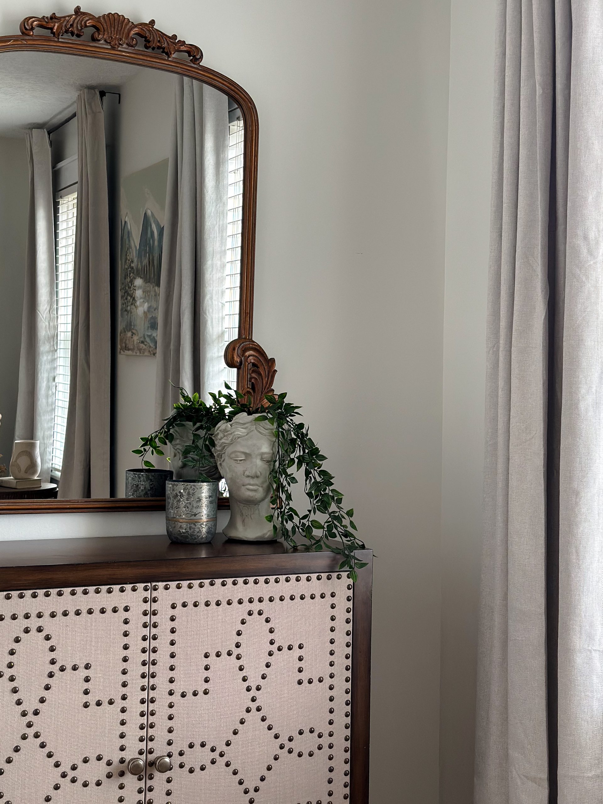 Bedroom nook with wooden decorative console and mirror.