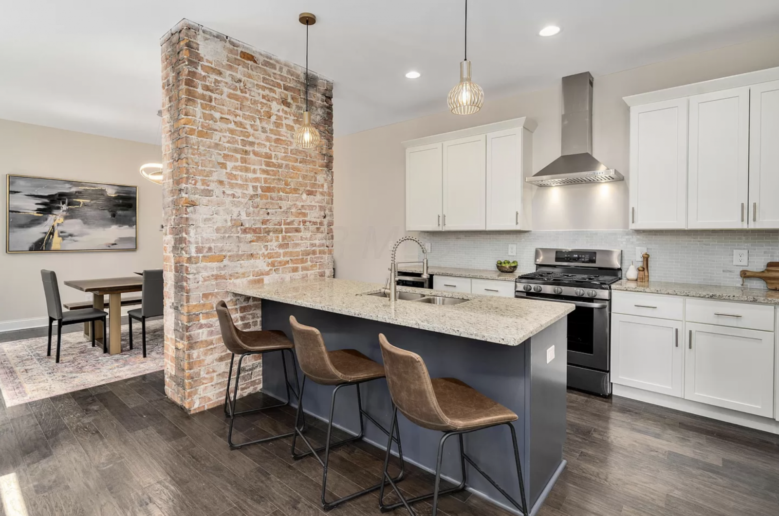 Fully renovated open kitchen with granite countertops, island seating and hardwood floors