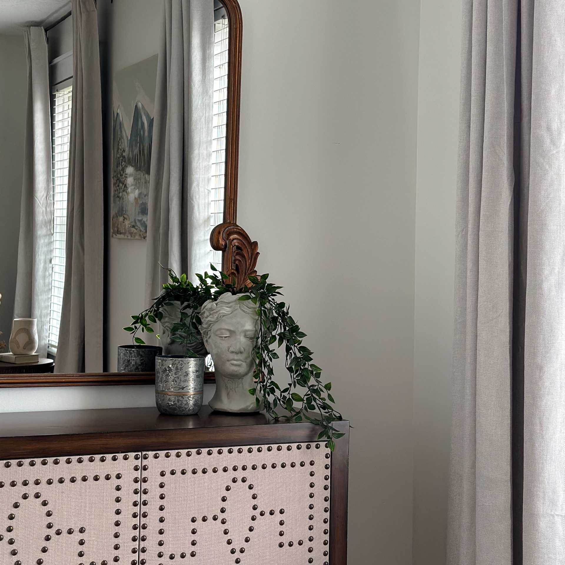 Bedroom nook with wooden decorative console and mirror.